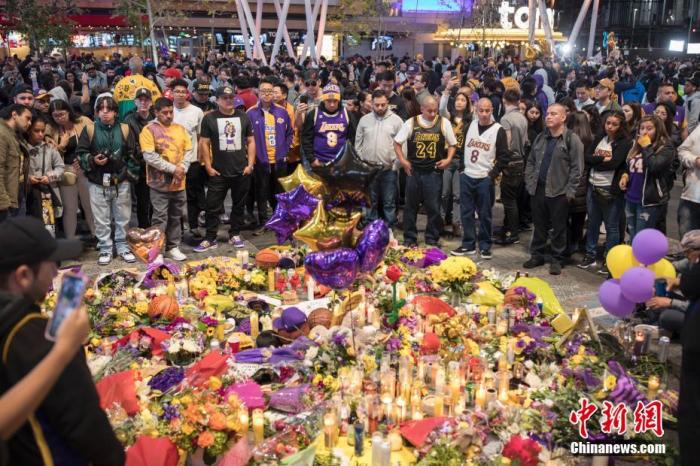 当地时间1月27日，球迷在NBA洛杉矶湖人队主场斯台普斯中心旁边的广场上悼念科比·布莱恩特。26日，科比·布莱恩特的私人直升机在加州小城卡拉巴萨斯坠毁，包括科比及其二女儿在内的机上9人全部遇难。/p中新社记者 刘关关 摄