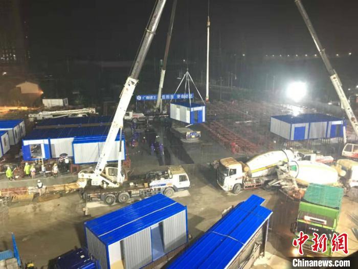 图为深夜中工人冒雨施工 赖俊杰 摄